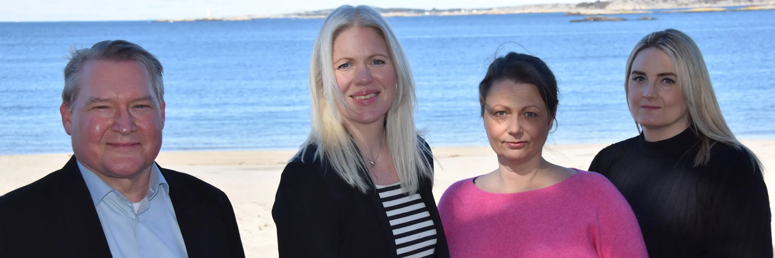 Anställda på Viscio Ekonomi på en strand framför havet